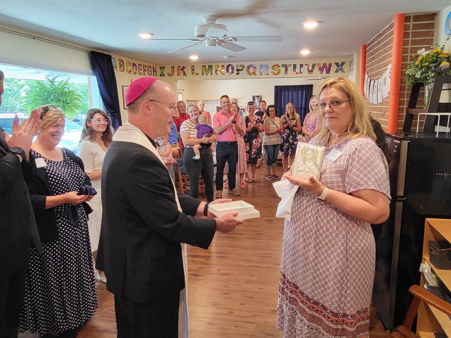 Leann Rockwell, director of the Immaculate Heart of Mary Child Development Center in Jefferson City, displays an image of the Blessed Mother and her Immaculate Heart, during the blessing and dedication ceremony of the center on Aug. 6.